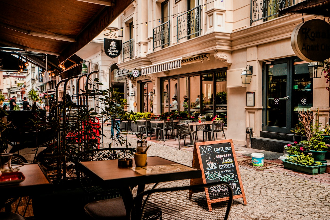 Mesas de restaurante na calçada de uma rua charmosa