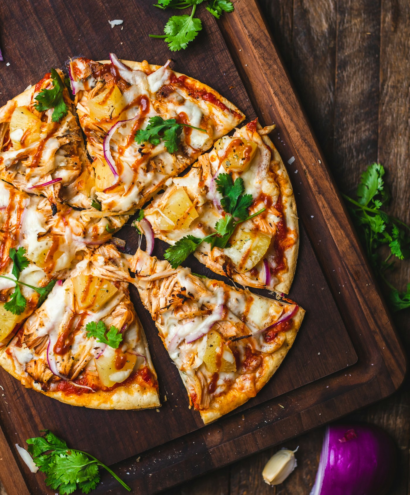 Pizza fatiada sobre tábua de madeira